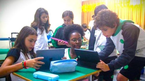 Professora em roda de alunos sobre bullying.