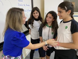 Representante da Mizzou Academy conversa com 3 alunas do 4º ano
