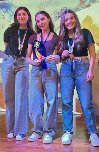 Três adolescentes meninas mostram troféu conquistado em torneio de foguetes